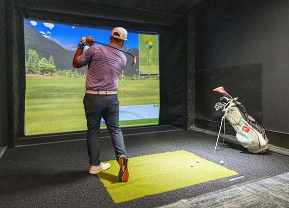 A man is playing golf in a virtual reality game.