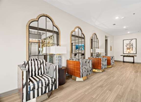 A room with striped chairs and wooden floors.