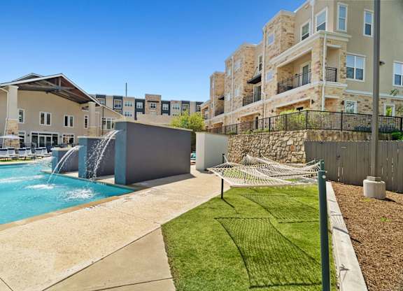 A swimming pool with a slide and a building in the background.