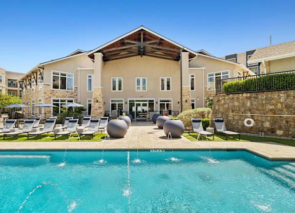 A large building with a pool in front of it.