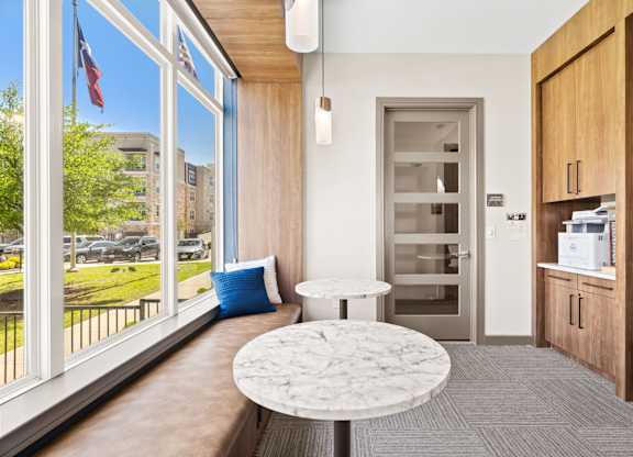 A white marble table is in the middle of a room with a window and a door.