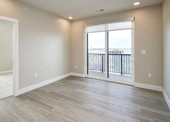 A spacious room with a view of a balcony.