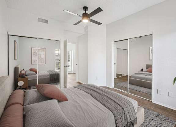 A bedroom with a large bed and a ceiling fan.