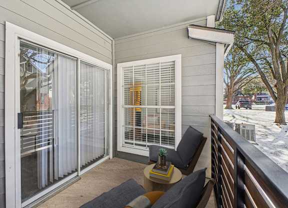 A balcony with a table and chairs is shown.