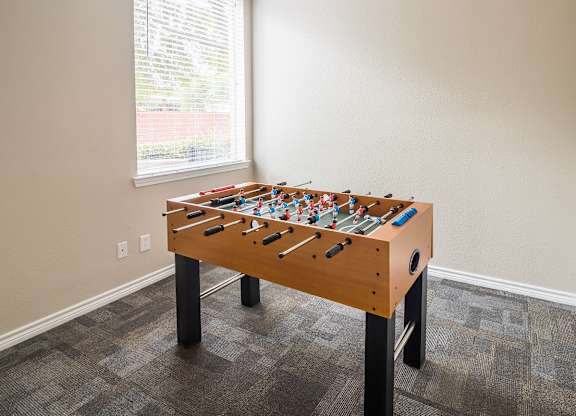 A foosball table in a room with a window.