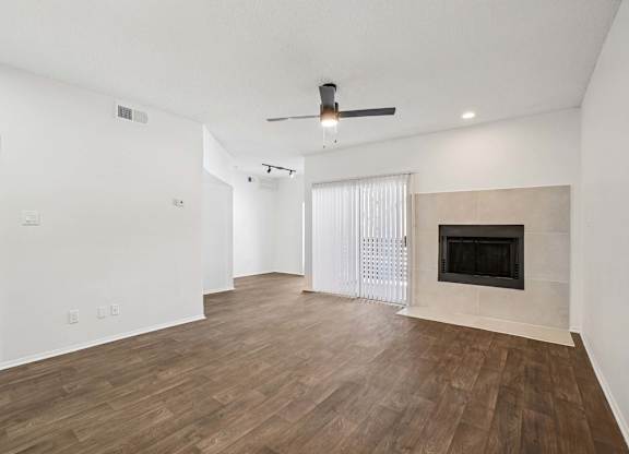 A room with a fireplace and a ceiling fan.