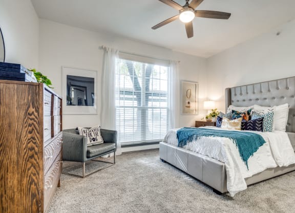 a bedroom with a bed and a ceiling fan