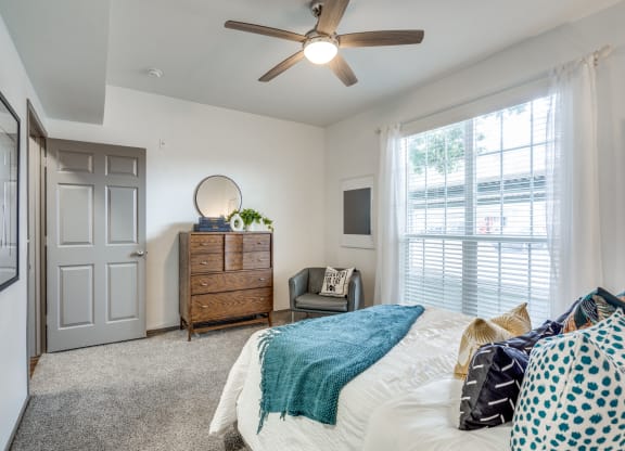 a bedroom with a bed and a ceiling fan
