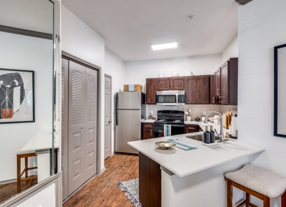 a kitchen with a white counter top and a stainless steel refrigerator