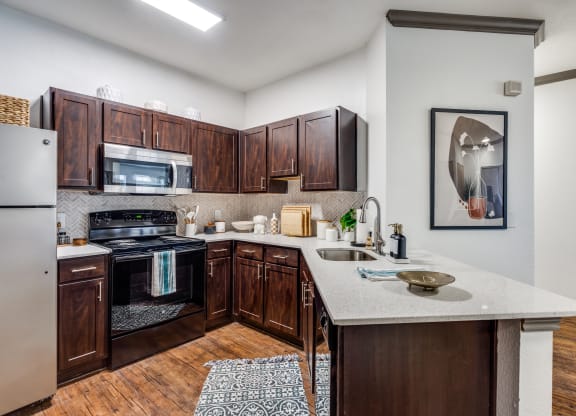 a kitchen with wooden cabinets and a marble counter top