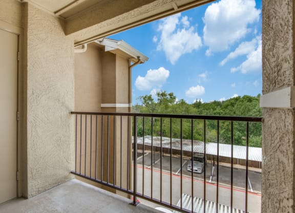 a balcony with a view of a building and a train yard