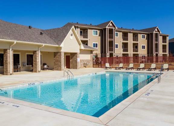 Parkside Apartments in Longview, Texas Clubhouse Exterior and Pool with Lounge Chairs