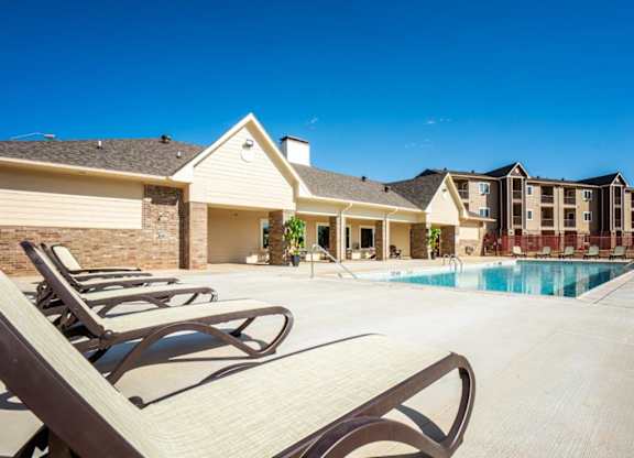 Parkside Apartments in Longview, Texas Clubhouse Exterior and Pool with Lounge Chairs