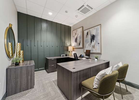 A modern office with a green wall and a wooden desk.