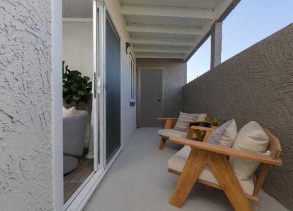 a porch with a wooden table and chairs on it
