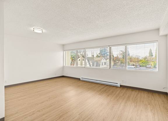 A room with a window overlooking a residential area.