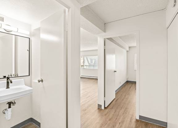 A white bathroom with a sink and mirror.