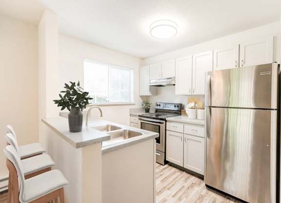 A kitchen with a white refrigerator and white cabinets.