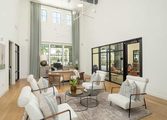 A living room with a white couch and a glass table.