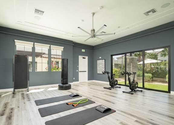 A room with exercise equipment and yoga mats.