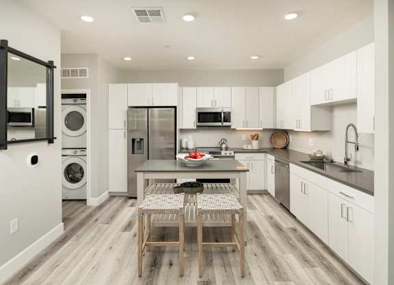 A modern kitchen with a dining table and chairs.