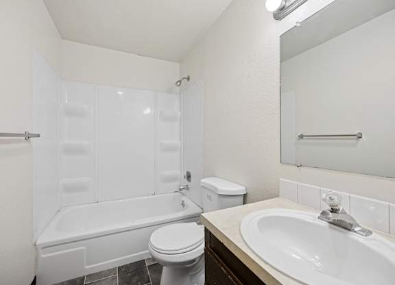 A white bathroom with a toilet, sink, and bathtub.