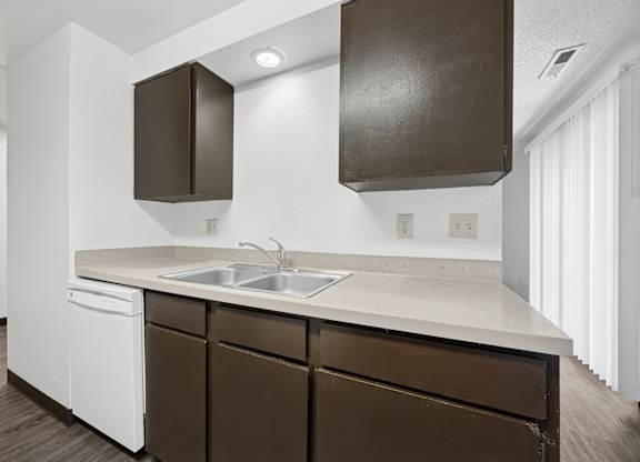 A kitchen with brown cabinets and white appliances.