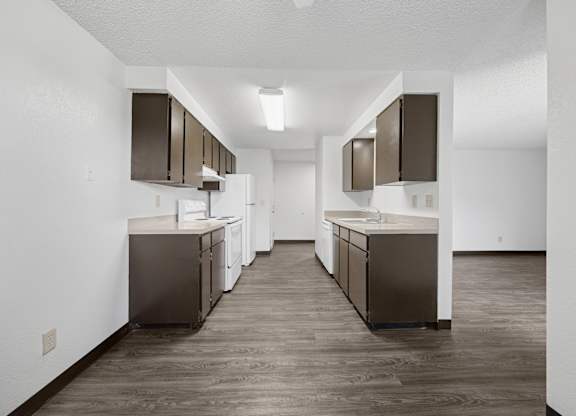 A kitchen with brown cabinets and a white wall.