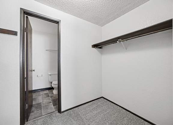 A bathroom with a toilet and sink is visible through an open door.