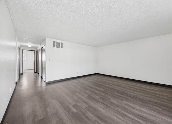 A room with wood flooring and white walls.