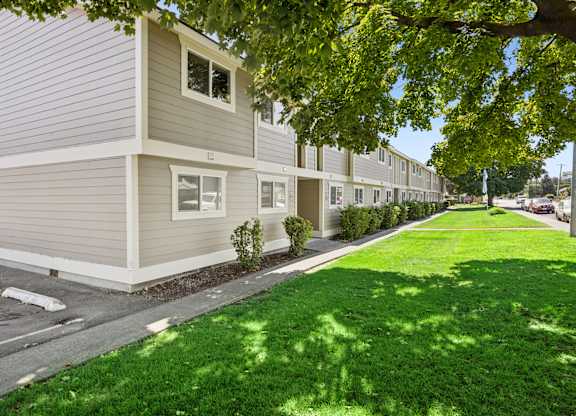 A row of houses with green lawns in front.