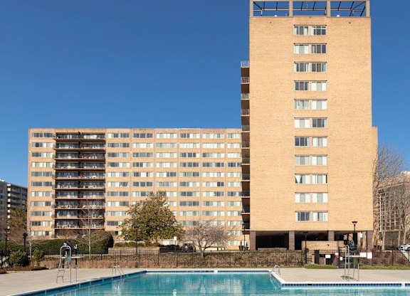 A large building with a pool in front of it.