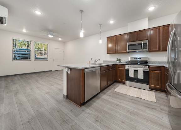 A modern kitchen with a white island and stainless steel appliances.
