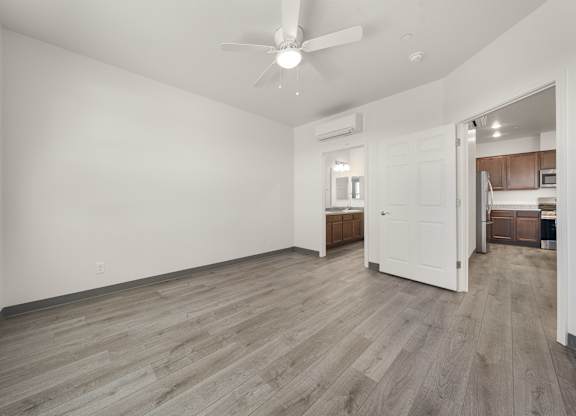 A room with a ceiling fan and wooden flooring.