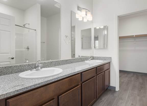 A bathroom with a sink, mirror, and wooden cabinets.