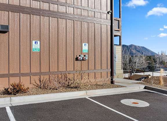 A parking lot with a building and a mountain in the background.