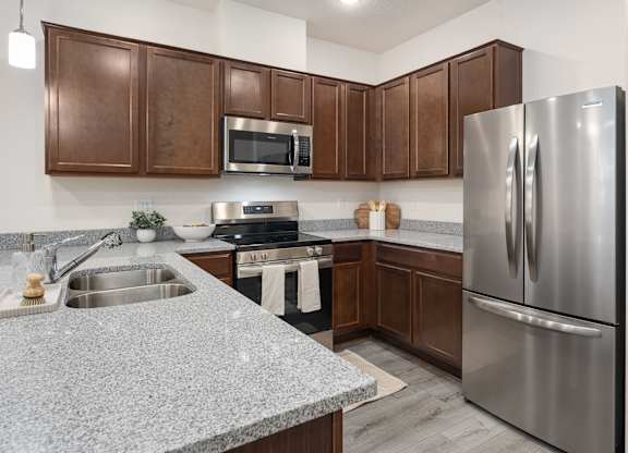 A modern kitchen with a stainless steel refrigerator and wooden cabinets.