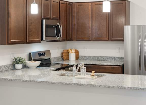 A kitchen with a microwave, sink, and refrigerator.