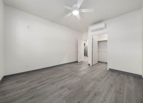 A room with a ceiling fan and a doorway leading to another room.