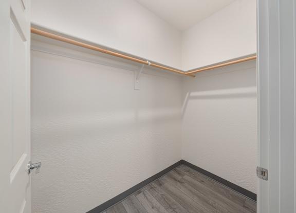 A white hallway with a wooden floor and white walls.