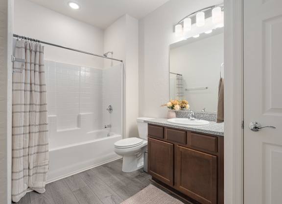 A white bathroom with a toilet, sink, and shower.