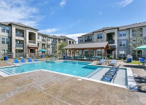 A large swimming pool in front of apartment buildings.