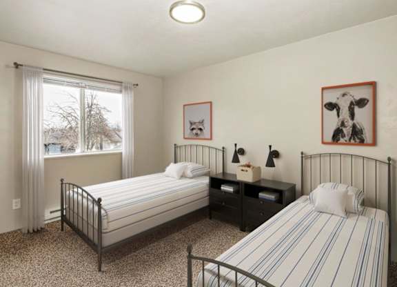 A bedroom with two beds, one with a striped bedspread.