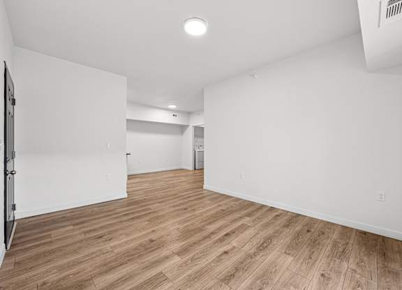 A room with wooden flooring and white walls.