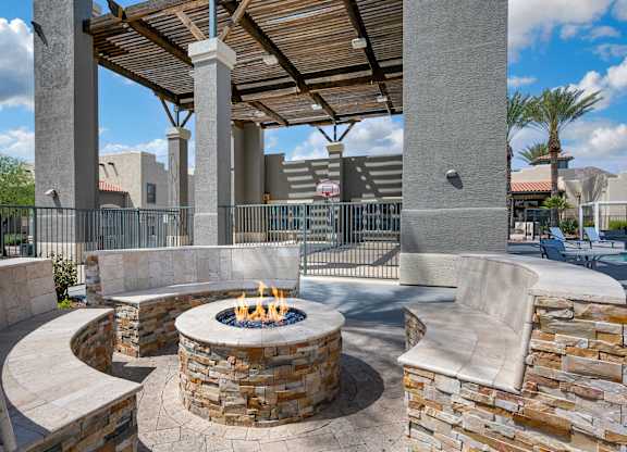 A patio with a fire pit and seating area.