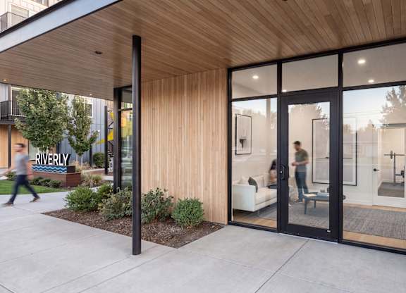 A modern building with a wooden exterior and glass doors.