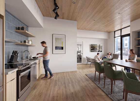 A woman is cooking in a modern kitchen with a wooden floor and ceiling.