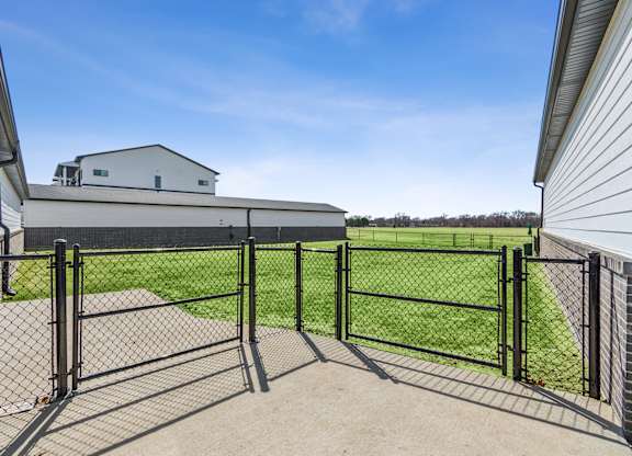 A black fence encloses a green field.