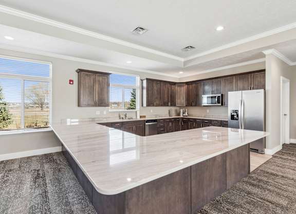 A modern kitchen with a large island and stainless steel appliances.