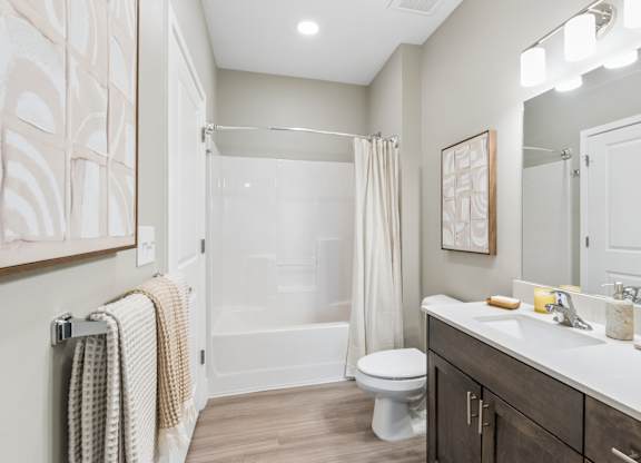 A bathroom with a toilet, sink, and shower.